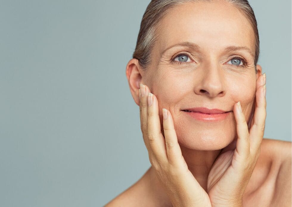Primer plano de una mujer con piel madura mostrando una tez luminosa y cuidada tras un tratamiento facial rejuvenecedor.
