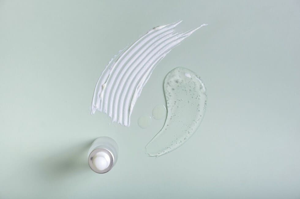 Muestra de sérum y crema de colágeno sobre fondo verde