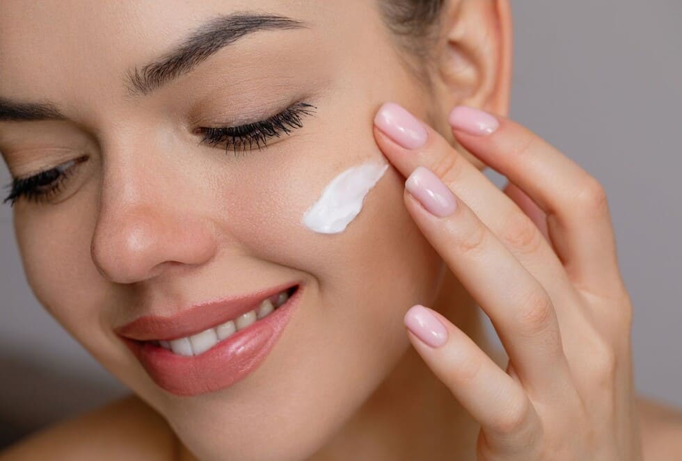 mujer aplicando serum para el rostro y evitar la aparicion de imperfecciones faciales